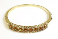 Lot 485 - An American citrine and diamond carved head style hinged bangle