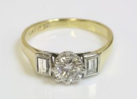 Lot 576 - A single stone diamond ring with step cut diamond shoulders