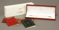 Lot 43 - A cased Cartier 'Must de Cartier' two colour Santos ball pen