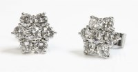 Lot 510 - A pair of seven stone diamond daisy cluster earrings