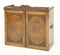 Lot 618 - An 18th century colonial amboyna and carved two door cabinet