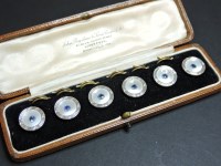 Lot 120 - A cased set of six mother of pearl and sapphire set buttons