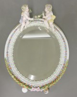 Lot 310 - An oval porcelain easel mirror