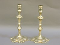 Lot 266 - A pair of George III brass petal base candlesticks
