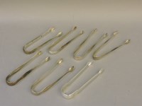 Lot 1127 - Seven George III silver bright cut sugar tongs