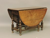 Lot 665 - An 18th century oak drop leaf dining table