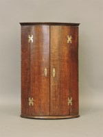 Lot 719 - An 18th century oak bow fronted corner cupboard