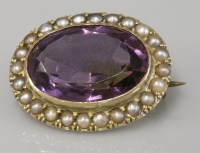 Lot 81 - An oval cut amethyst and split pearl brooch
