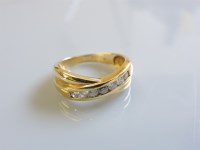 Lot 4 - An 18ct gold channel set crossover diamond ring