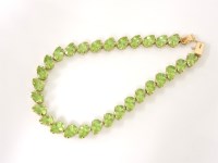 Lot 1014 - A 9ct gold pear cut peridot line bracelet