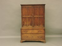 Lot 1515 - A Georgian oak cupboard with drawers beneath