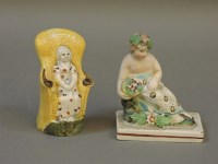 Lot 287 - An antique pearlware model of a young girl in a chair