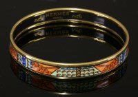 Lot 1003 - An Hermès narrow orange enamel gold-plated bangle