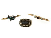 Lot 1189A - A gold three stone rub set garnet and aquamarine bar brooch