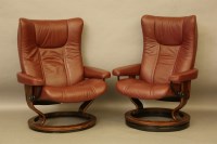 Lot 414 - A pair of modern leather upholstered revolving and reclining arm chairs