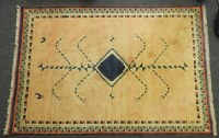 Lot 526 - A Turkish handmade wool rug with geometric motifs on a peach ground