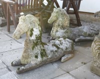Lot 906 - A pair of composition stone recumbent horses