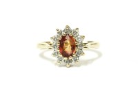 Lot 23 - A 9ct gold orange sapphire and diamond cluster ring