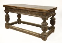 Lot 571 - A Continental oak draw-leaf table