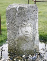 Lot 1088 - A corner stone fragment with inset hand carved face of a girl