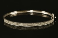Lot 726 - A 9ct white gold two row diamond hinged bangle