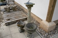 Lot 657 - A sundial on a stone pedestal and two composition stone urns