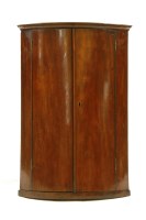 Lot 436 - A George III mahogany 'Barrel' front corner cupboard