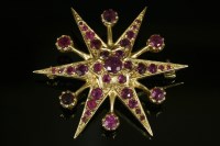 Lot 496 - A 9ct gold ruby starburst brooch
