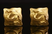Lot 517 - A pair of Chanel gold-plated monogrammed clip-on earrings.
a raised entwined double 'C' monogram to a plain background with a slight scalloped diamond shaped border