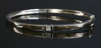 Lot 394 - An 18ct white gold single stone diamond hinged bangle