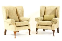 Lot 548 - A pair of George III style overstuffed upholstered wing back armchairs