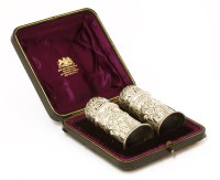 Lot 97 - A pair of late Victorian embossed silver pepper pots