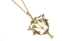 Lot 14 - An Edwardian gold peridot and split pearl open frame pendant