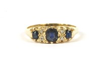 Lot 147 - An 18ct gold carved head three stone sapphire ring