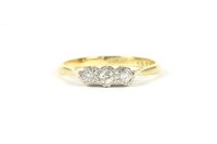Lot 15 - A gold three stone illusion set diamond ring