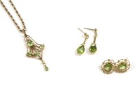 Lot 69 - An Edwardian peridot and split pearl open scroll pendant