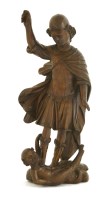Lot 521 - A walnut carving of Saint Michael battling Satan