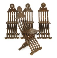 Lot 776 - A matched set of four Indian inlaid and carved hardwood folding chairs