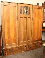 Lot 568 - An Arts and Crafts oak double wardrobe