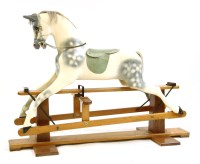 Lot 597 - A carved wooden and dapple grey painted rocking horse