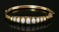 Lot 108 - An Edwardian 9ct gold hinged opal bangle, c.1900
