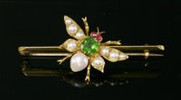 Lot 97 - An Edwardian gold, green paste, ruby and split pearl set insect bar brooch, c.1905
