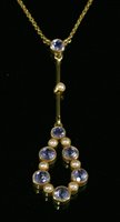Lot 101 - An Edwardian gold sapphire and split pearl Edna May style pendant, c.1910