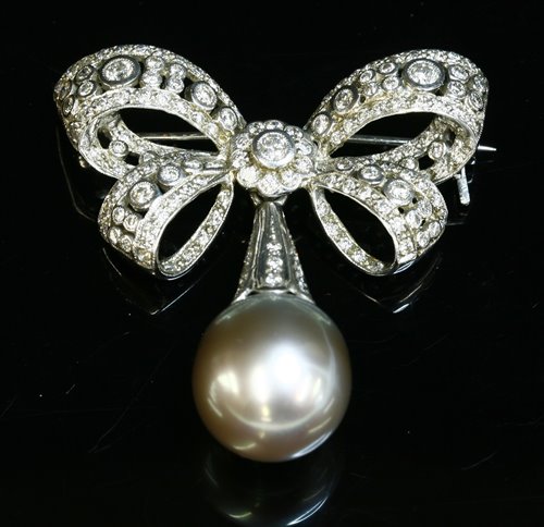Lot 334 - A white gold Tahitian cultured pearl and diamond bow brooch
