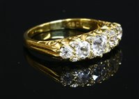 Lot 61 - A five stone graduated diamond carved head style ring