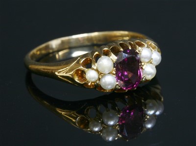 Lot 105 - An Edwardian garnet and pearl boat-shaped ring