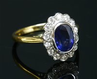 Lot 322 - An 18ct yellow and white gold sapphire and diamond oval cluster ring
