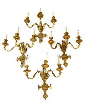 Lot 857 - A set of four three-branch gilt metal wall lights