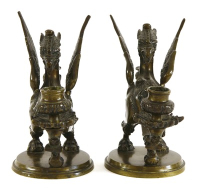 Lot 501 - A pair of dark brown patinated bronze griffin/wyvern candlesticks