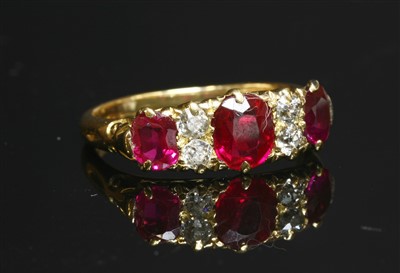 Lot 63 - An 18ct gold synthetic ruby and diamond carved head ring